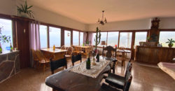 A house with a garden and a restaurant with panoramic views of the ocean and the city.