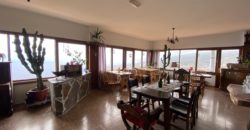 A house with a garden and a restaurant with panoramic views of the ocean and the city.