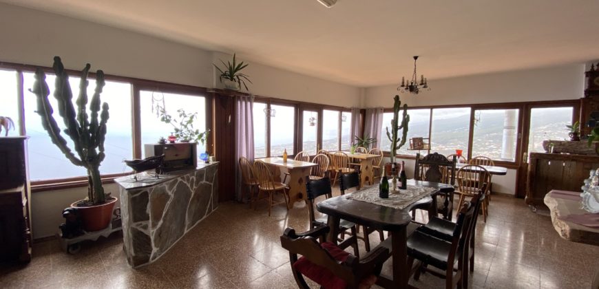 A house with a garden and a restaurant with panoramic views of the ocean and the city.