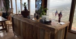 A house with a garden and a restaurant with panoramic views of the ocean and the city.