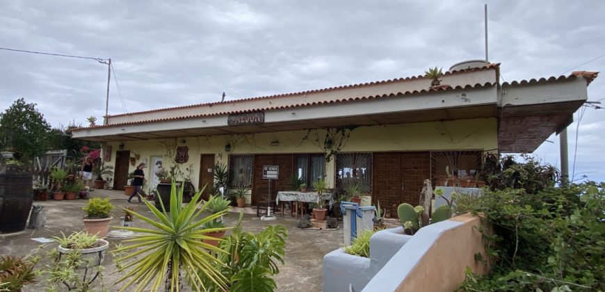 A house with a garden and a restaurant with panoramic views of the ocean and the city.